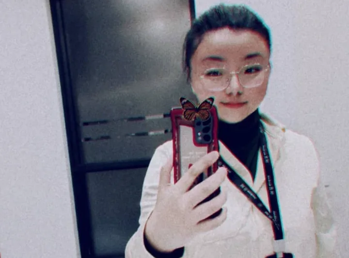 Ruitong Tang wearing a work lanyard in an office corridor